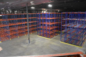 An empty warehouse full of racking shelves.