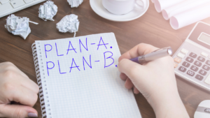 An employee writing Plan A and Plan B on a notebook.