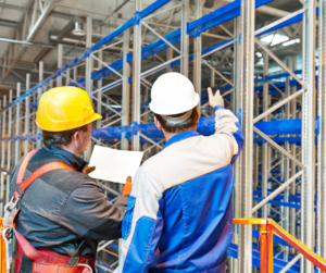 Employees checking out warehouse shelving.